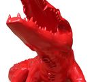 un alligator rouge qui est assis par terre