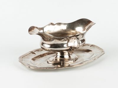 une assiette en argent sur laquelle sont posés une soucoupe et une cuillère