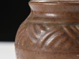 a brown vase that is sitting on a table
