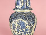 un vase bleu et blanc surmonté d'un chat