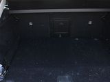 the back of a white car with its trunk open and the back seats down