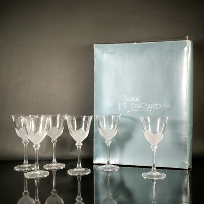 six verres à vin posés sur une table, à côté d'une boîte