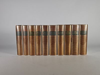 un ensemble de cinq livres anciens posés sur une surface blanche