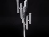 un gros plan d'une sculpture métallique posée sur un socle, sur fond noir