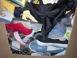 a cardboard box filled with shoes and other items