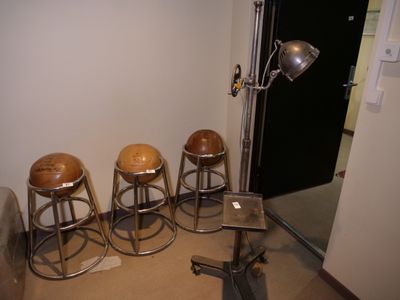quatre tabourets dans un coin d'une pièce où se trouve une lampe