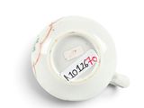 a white cup with a sticker on the side of it