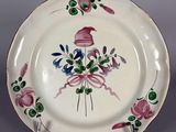 une assiette blanche ornée d'un motif rose et vert