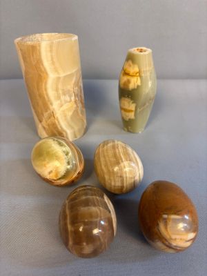 Plusieurs vases de styles différents sont posés sur une surface bleue.