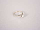 a close up of a white gold ring with a single diamond