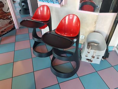 two red chairs sitting on a blue and pink checkered floor