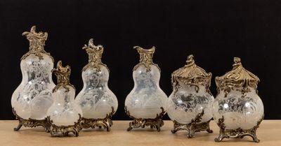 six silver and glass vases sitting on top of a wooden table