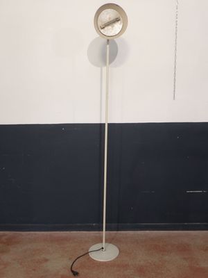 a white floor lamp with a circular light on it