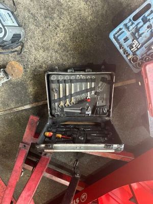 de nombreux outils qui sont rangés dans une mallette posée par terre
