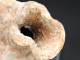 a hand holding a piece of clay with a hole in it