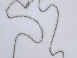 a silver necklace with a curved design on a chain