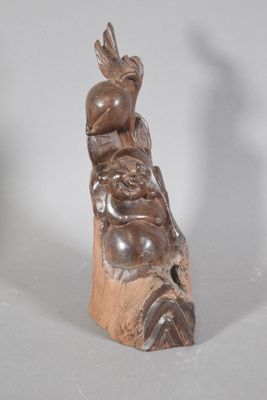 a small statue of a man sitting on top of a rock
