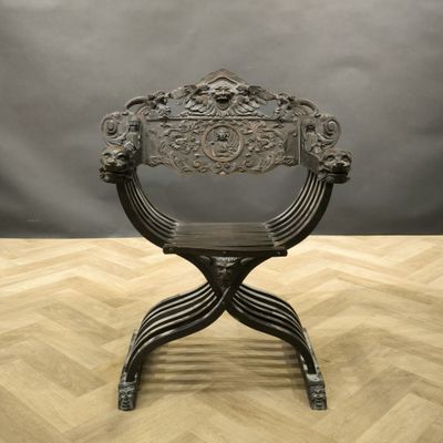 an antique iron chair on a wooden floor with a gray background