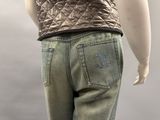 a female mannequin wearing a quilted vest and jeans