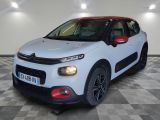 une voiture blanche de marque Citrole garée sur un sol à damier dans un garage