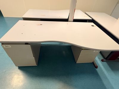 un bureau blanc avec un ordinateur dans une pièce