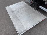 a metal ramp on the ground next to a truck