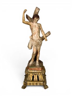 une statue ancienne représentant un homme armé d'une épée, posée sur un socle