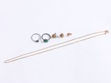 three different rings and a necklace on a white surface