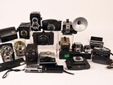 a lot of old cameras that are sitting on a table