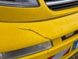 a close up of a yellow car with a red and white stripe on it