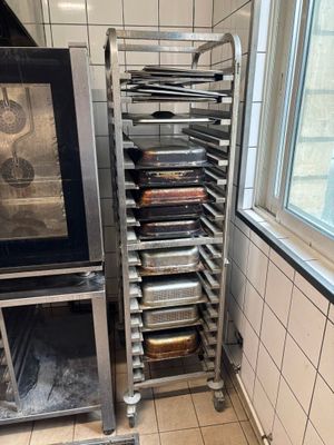 many trays of food that are on a rack in the kitchen