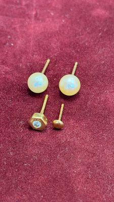 two pairs of oplite earrings on a red velvet surface
