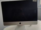 un écran d'ordinateur posé sur un bureau blanc