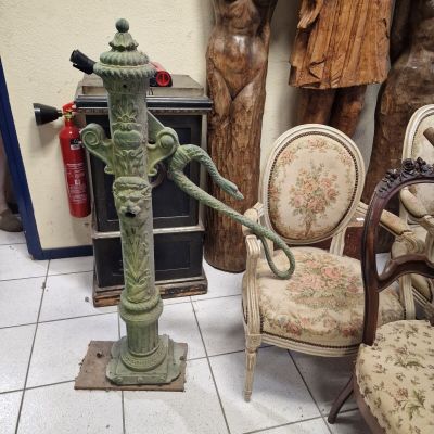 a green fire hydrant sitting on a pedestal in a room