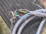 a cat that is sitting on the floor next to some wires