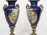 pair of blue and gold vases with images of people on them