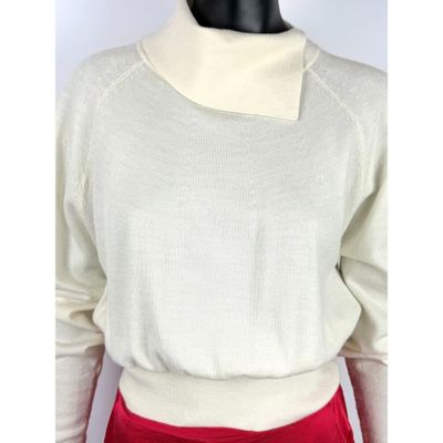 un gros plan sur un mannequin portant un pull blanc et un pantalon rouge