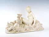 une statue représentant une femme assise sur un rocher, à côté d'un chien