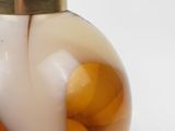 a soap dispenser with oranges in it on a white surface