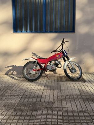 a red motorcycle parked in front of a tan building