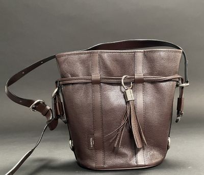 brown leather purse with tassels on a grey background