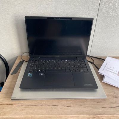 un ordinateur portable posé sur un bureau en bois