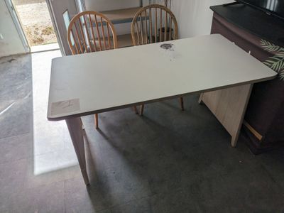 a table and chairs in a room with a television