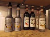 many bottles of liquor on a shelf in a kitchen