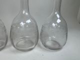 three empty glass bottles sitting on a white surface