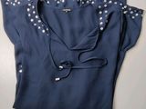 the shirt is blue and has white polka dots on it