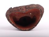 a brown vase with a hole in it on a white surface