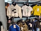 many shirts on display in the store for sale