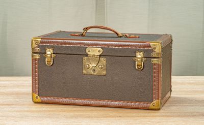 a brown and tan suitcase sitting on a wooden table