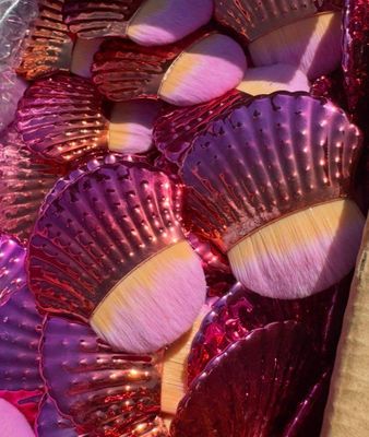 une boîte remplie de coquillages roses et violets posée sur une table